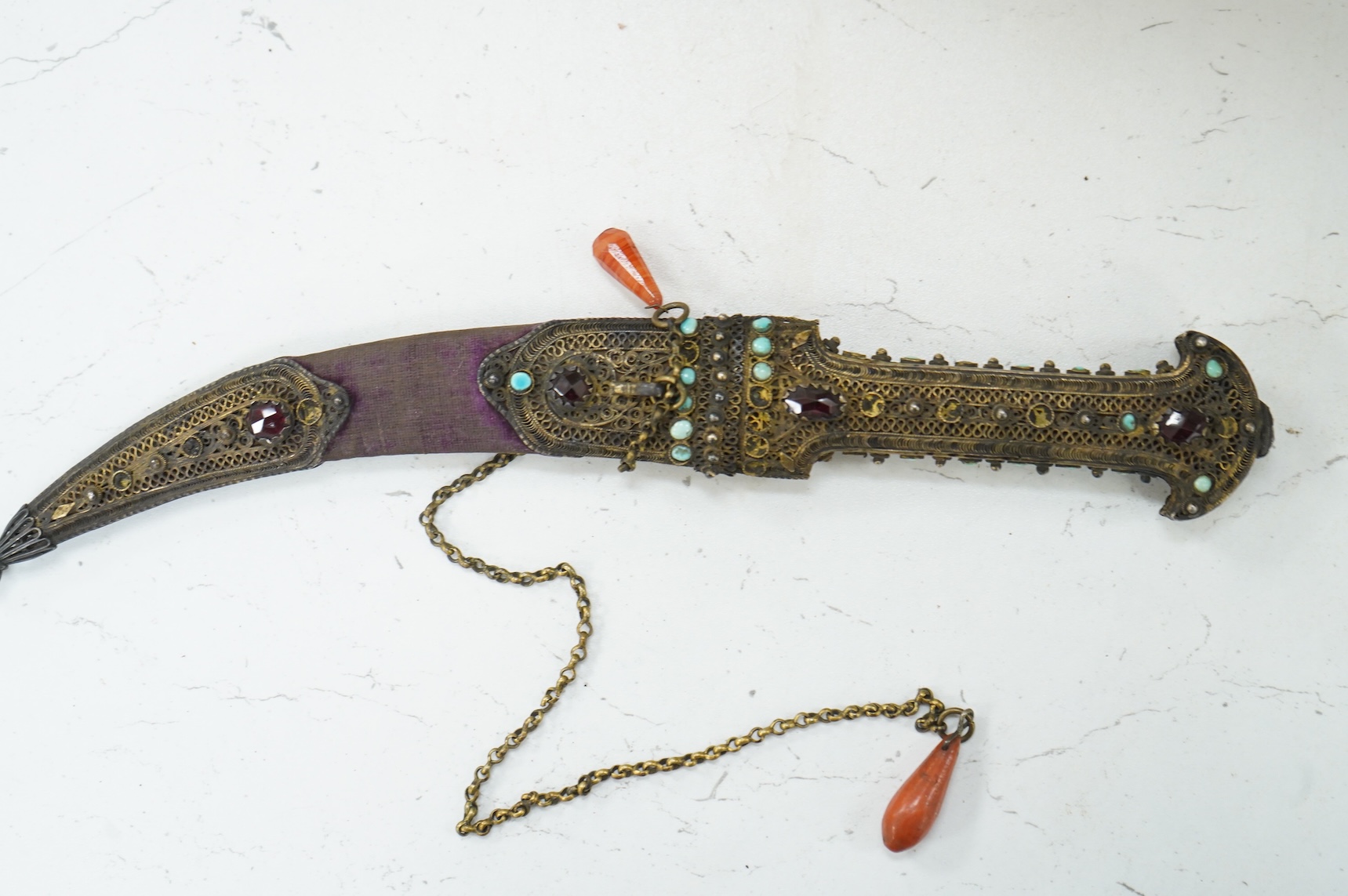 A Late 19th century Hungarian dagger, the hilt and sheath mounts made from filigree gilt silver wire applied with cabochon turquoise and red stones (some missing), blade 13.5cm